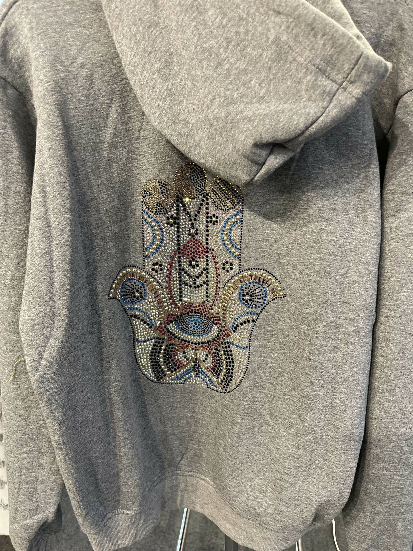 Grey zipper with hoodie sweatshirt with rainbow rhinestone applique. Rhinestone with hamsa on back